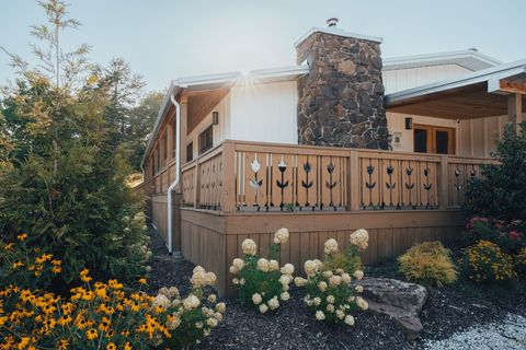 Stone chimney and summer gardens at the entrance to Sommer House Inn on Highway 74